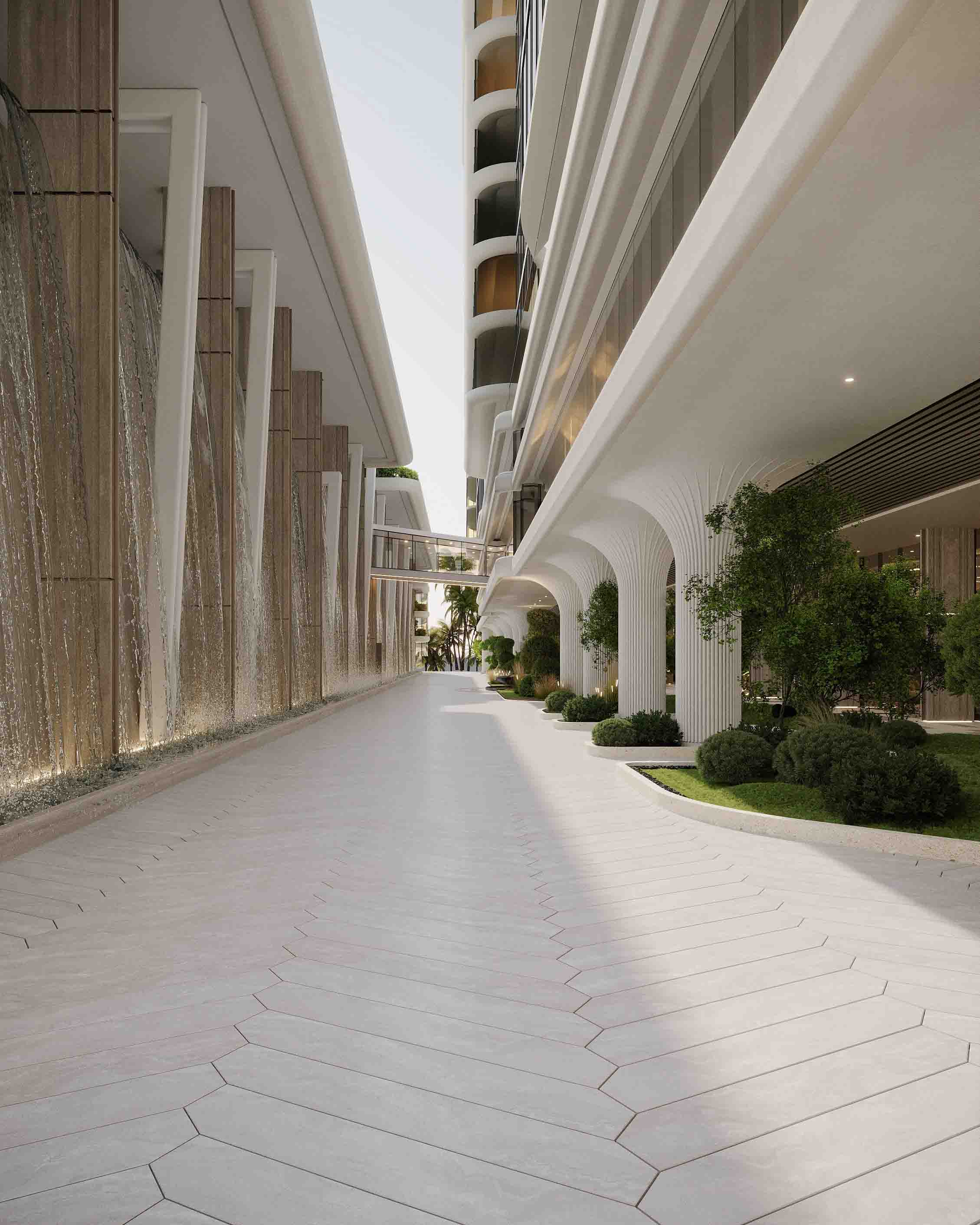 Elegant drop-off entrance featuring sculpted columns, curated greenery and a reflective water feature.