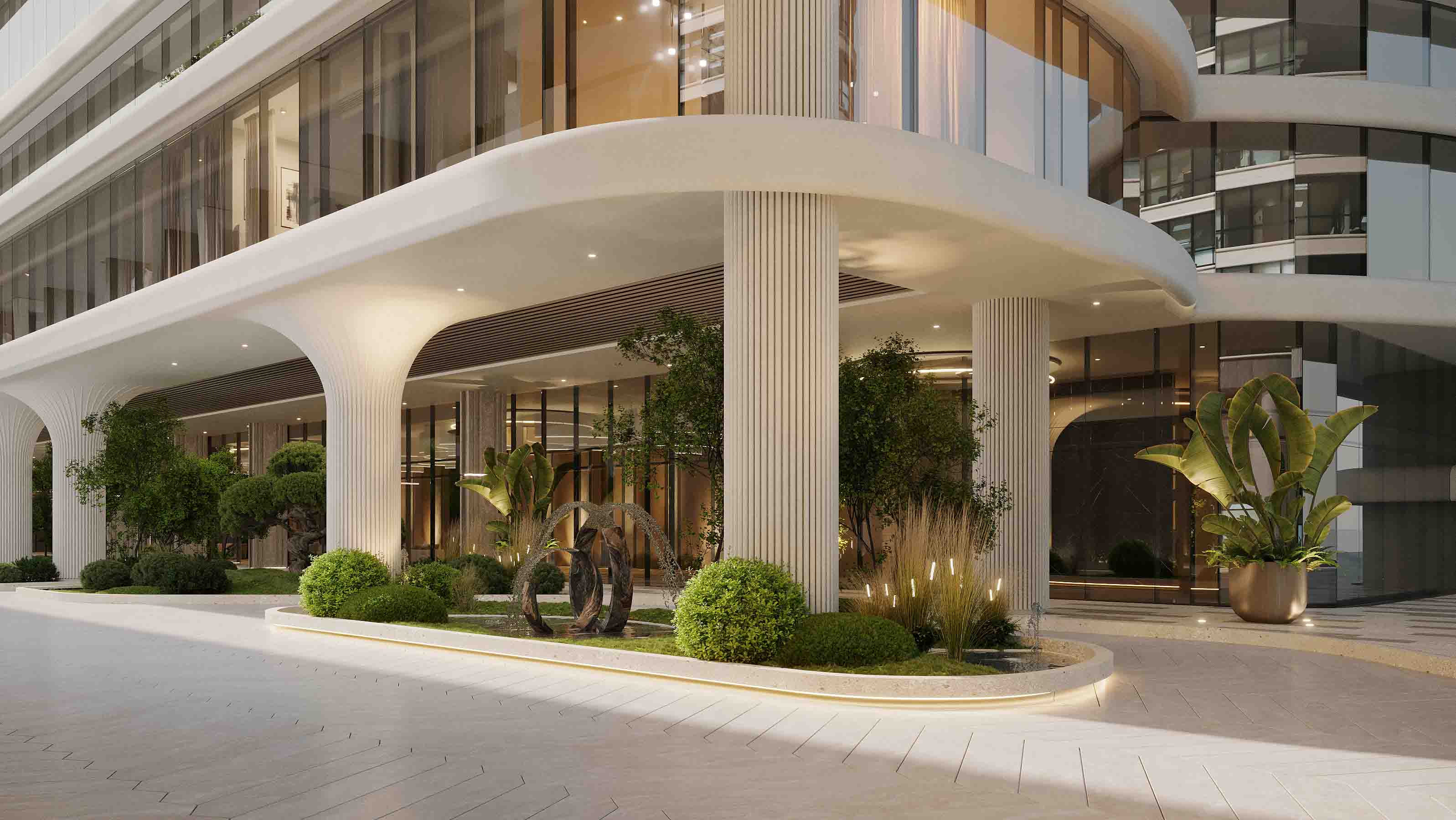Elegant porte-cochère with fluted white columns, lush landscaping and floor-to-ceiling glass.