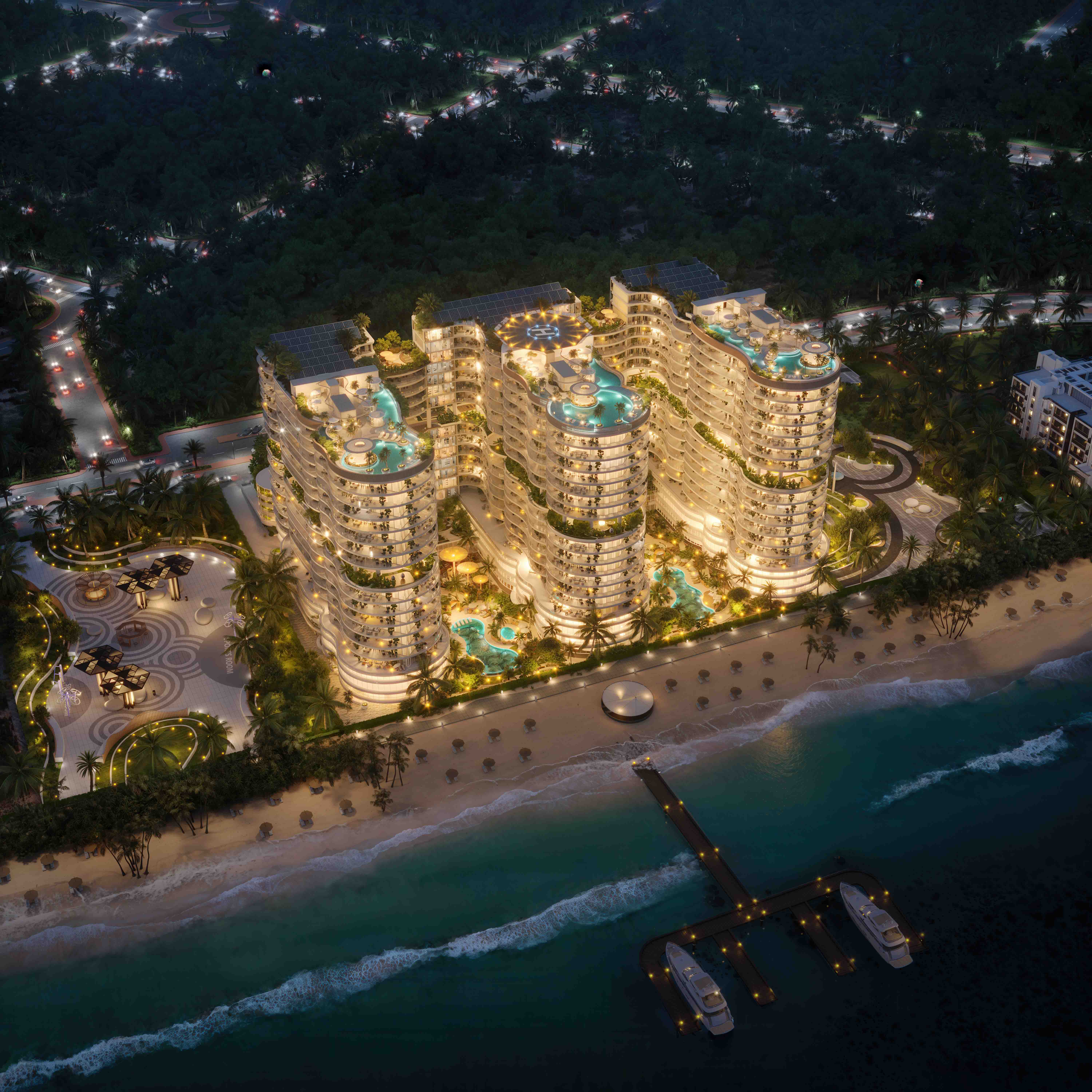 Night view of AMRA fully illuminated, with glowing pools, beachfront and private yacht pier.